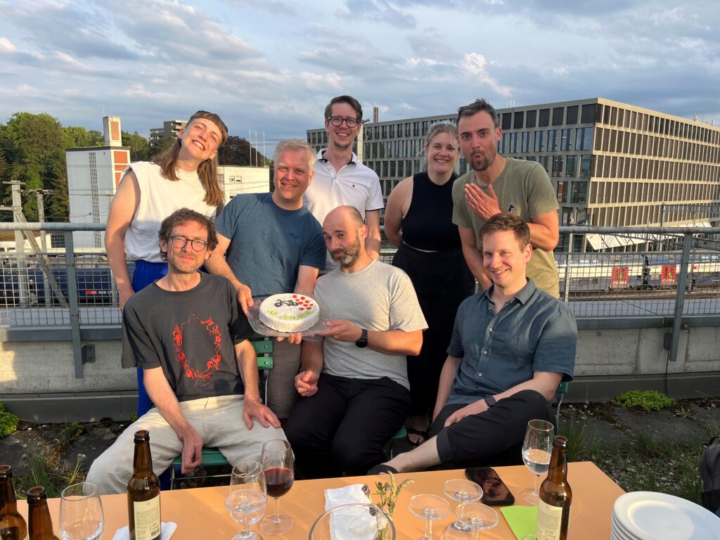 Team Metron Bern auf der Dachterrasse mit Jubiläumstorte zur GV / MAV