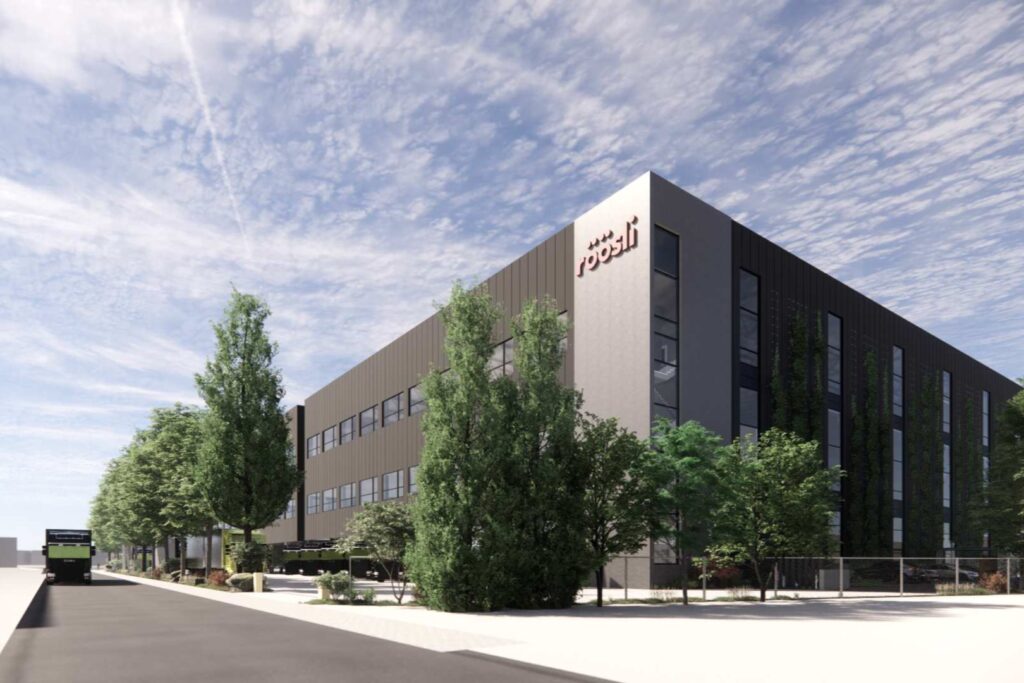 Die Visualisierung zeigt die neue Halle der Röösli Logistik in Emmen hinter Bäumen und grossen Sträuchern.