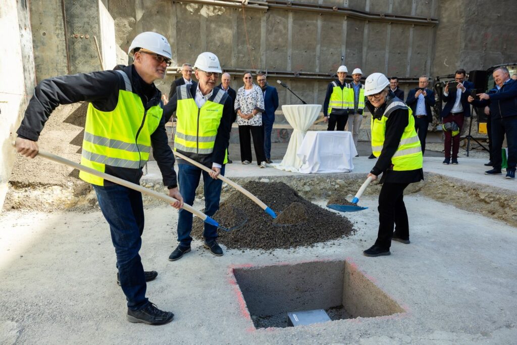 Grundsteinlegung Spital Bülach. Roger Trottmann (Generalplaner, Metron Architektur AG), Thomas Straubhaar (Verwaltungsratspräsident) und Mariette Gretler (CEO a. i., Verantwortliche für die Bauprojekte) lassen Zeitkapsel in Baugruppe, Bild: Fotostudio Baur